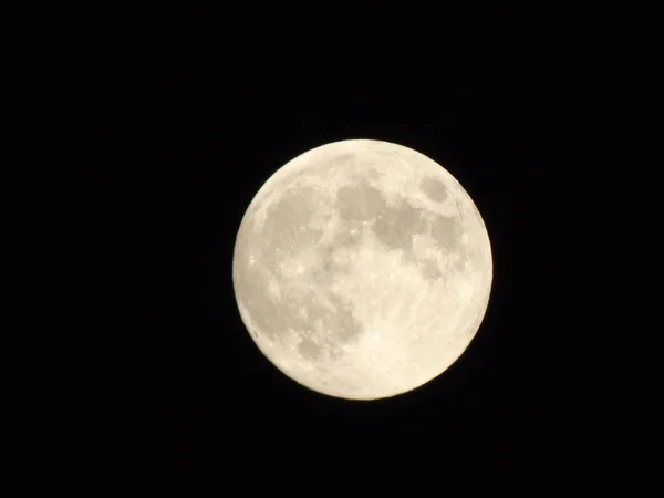 An amazing photography of the full moon over the city of Genova by night with a great clear sky in background and some stars