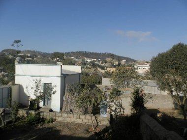 Eritre, Afrika - 08 / 10 / 2019: Asmara ve Massawa yakınlarındaki vilajları gezmek. Ağaçların, dağların ve Eritre 'de iklimi çok sıcak olan bazı eski tipik evlerin inanılmaz bir başlığı..