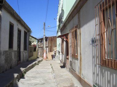 Valpariso, Şili - 26.12.2018: Güzel renkli sokaklar, evler ve Valpariso barakaları. Bazı dalgalar ile okyanustan büyük görünümü.