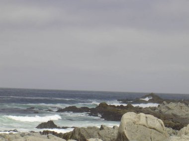 Valpariso, Şili - 26.12.2018: Güzel renkli sokaklar, evler ve Valpariso barakaları. Bazı dalgalar ile okyanustan büyük görünümü.