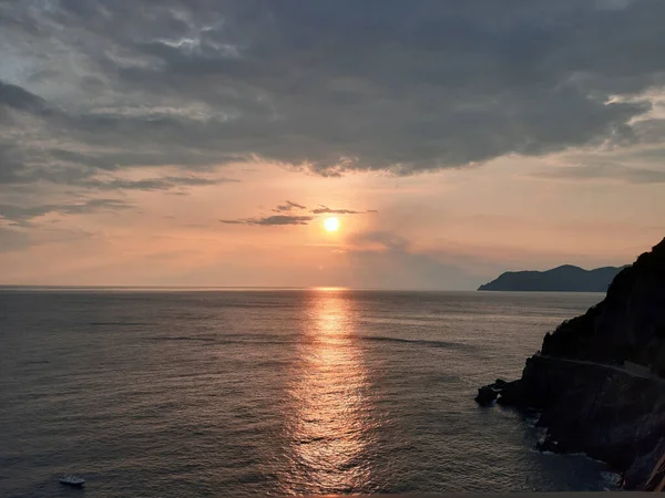 Genova, Italy - 06/18/2020: Beautiful photography of the sunset over the sea and clouds reflection on the water. Panoramic view to the ligurian coast in spring days.