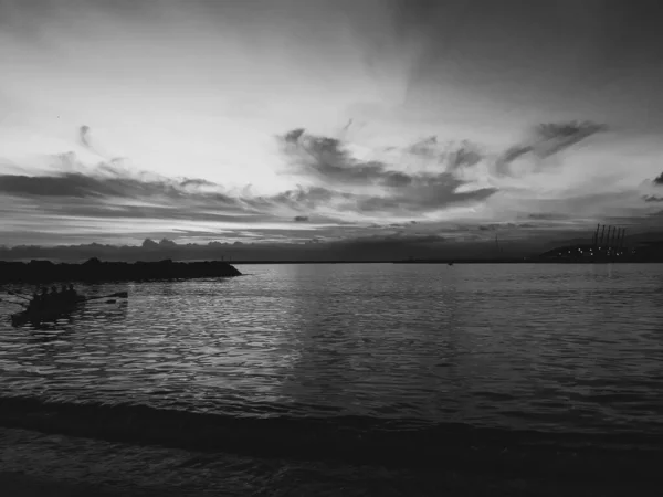 Genova, Italy - 06/18/2020: Beautiful photography of the sunset over the sea and clouds reflection on the water. Panoramic view to the ligurian coast in spring days.