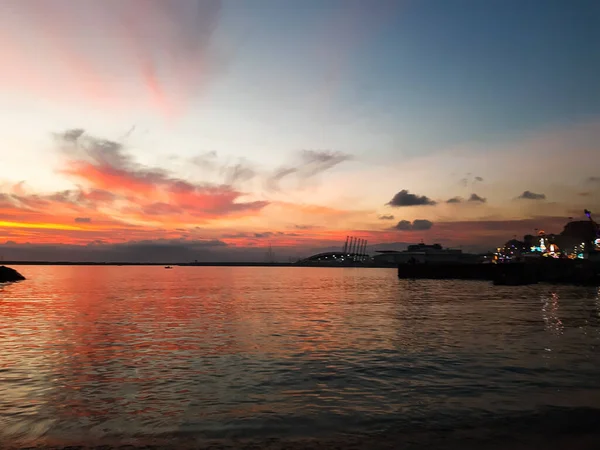 Genova, Italy - 06/18/2020: Beautiful photography of the sunset over the sea and clouds reflection on the water. Panoramic view to the ligurian coast in spring days.