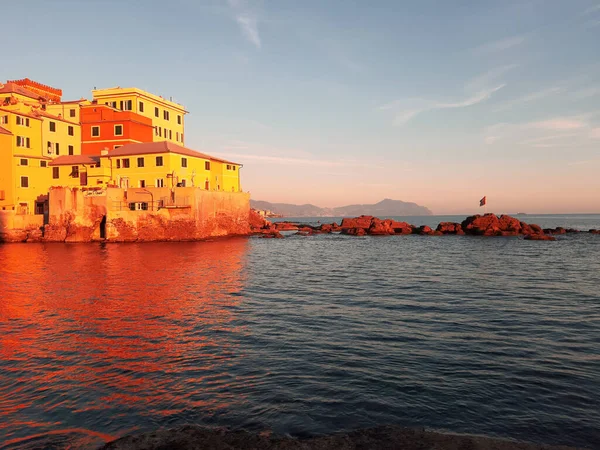 Genova, Italy - 06/18/2020: Beautiful photography of the sunset over the sea and clouds reflection on the water. Panoramic view to the ligurian coast in spring days.