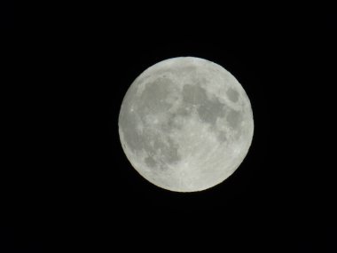 Cenova, İtalya - 07 / 05 / 2020: Geceleyin Cenova şehrinde dolunayın inanılmaz bir fotoğrafı ve arka planda büyük açık ve mavi bir gökyüzü ve bazı yıldızlar.