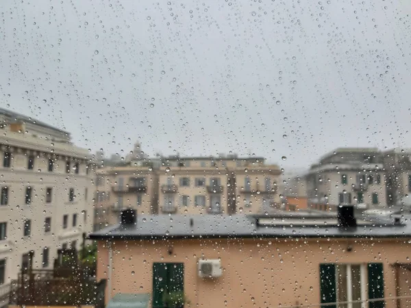 Beautiful photography of the waterdrop over the window. Indoor panoramic view to the city after rain.