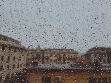 Pencerenin üzerindeki su damlasının güzel bir fotoğrafı. Yağmurdan sonra şehir için kapalı panoramik manzara.
