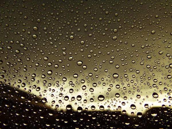 Beautiful photography of the waterdrop over the window. Indoor panoramic view to the city after rain.