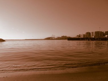 Liguria, İtalya - 08 / 15 / 2020: Yaz günlerinde su üzerinde bulanık arkaplan için gündoğumunun yansıması. Yaz günlerinde açık mavi gökyüzü sıcak iklim.