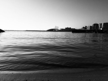 Liguria, İtalya - 08 / 15 / 2020: Yaz günlerinde su üzerinde bulanık arkaplan için gündoğumunun yansıması. Yaz günlerinde açık mavi gökyüzü sıcak iklim.