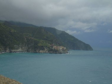 Cinque Terre, İtalya - 08 / 31 / 2020: Bir kıyı balıkçı köyünün güzel manzarası, pek çok küçük renkli ev manzarası, Cinque Terre adlı küçük İtalyan kasabasının geleneksel mimarisi