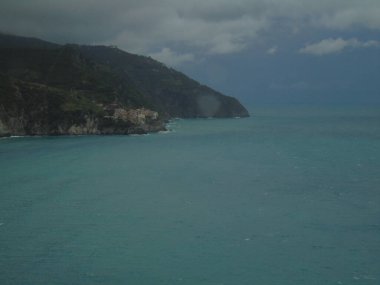 Cinque Terre, İtalya - 08 / 31 / 2020: Bir kıyı balıkçı köyünün güzel manzarası, pek çok küçük renkli ev manzarası, Cinque Terre adlı küçük İtalyan kasabasının geleneksel mimarisi