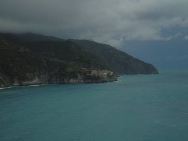 Cinque Terre, İtalya - 08 / 31 / 2020: Bir kıyı balıkçı köyünün güzel manzarası, pek çok küçük renkli ev manzarası, Cinque Terre adlı küçük İtalyan kasabasının geleneksel mimarisi
