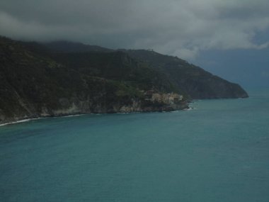 Cinque Terre, İtalya - 08 / 31 / 2020: Bir kıyı balıkçı köyünün güzel manzarası, pek çok küçük renkli ev manzarası, Cinque Terre adlı küçük İtalyan kasabasının geleneksel mimarisi