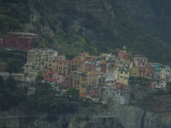 Cinque Terre, İtalya - 08 / 31 / 2020: Bir kıyı balıkçı köyünün güzel manzarası, pek çok küçük renkli ev manzarası, Cinque Terre adlı küçük İtalyan kasabasının geleneksel mimarisi