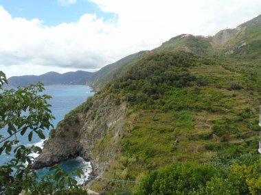 Cinque Terre, İtalya - 08 / 31 / 2020: Bir kıyı balıkçı köyünün güzel manzarası, pek çok küçük renkli ev manzarası, Cinque Terre adlı küçük İtalyan kasabasının geleneksel mimarisi