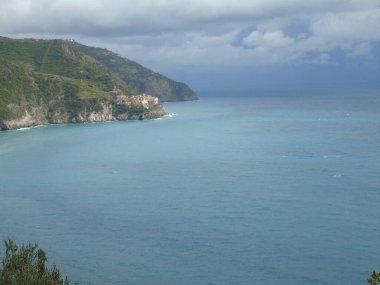 Cinque Terre, İtalya - 08 / 31 / 2020: Bir kıyı balıkçı köyünün güzel manzarası, pek çok küçük renkli ev manzarası, Cinque Terre adlı küçük İtalyan kasabasının geleneksel mimarisi