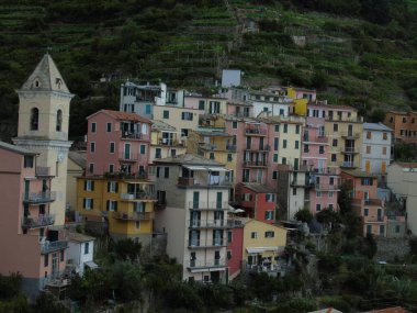 Cinque Terre, İtalya - 08 / 31 / 2020: Bir kıyı balıkçı köyünün güzel manzarası, pek çok küçük renkli ev manzarası, Cinque Terre adlı küçük İtalyan kasabasının geleneksel mimarisi