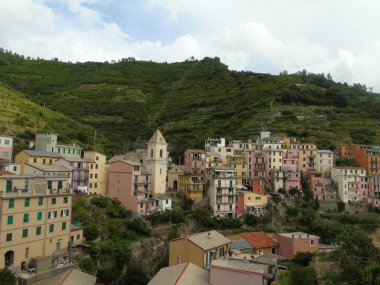 Cinque Terre, İtalya - 08 / 31 / 2020: Bir kıyı balıkçı köyünün güzel manzarası, pek çok küçük renkli ev manzarası, Cinque Terre adlı küçük İtalyan kasabasının geleneksel mimarisi