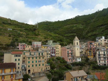 Cinque Terre, İtalya - 08 / 31 / 2020: Bir kıyı balıkçı köyünün güzel manzarası, pek çok küçük renkli ev manzarası, Cinque Terre adlı küçük İtalyan kasabasının geleneksel mimarisi