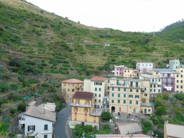 Cinque Terre, İtalya - 08 / 31 / 2020: Bir kıyı balıkçı köyünün güzel manzarası, pek çok küçük renkli ev manzarası, Cinque Terre adlı küçük İtalyan kasabasının geleneksel mimarisi