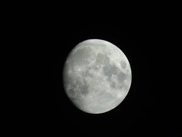 Genova, Italy - 07/07/2020: An amazing photography of the full moon over the city of Genova by night with a great clear and black sky in the background and some stars.