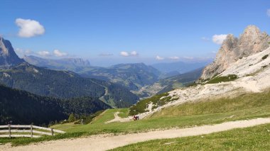 Val Gardena, İtalya - 09 / 15 / 2020: Arka planda büyülü Dolomitler dağları, Trentino Alto Adige bölgesinde inanılmaz bulutlar ve mavi gökyüzü, İtalya, Avrupa
