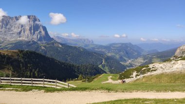 Val Gardena, İtalya - 09 / 15 / 2020: Arka planda büyülü Dolomitler dağları, Trentino Alto Adige bölgesinde inanılmaz bulutlar ve mavi gökyüzü, İtalya, Avrupa