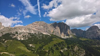 Val Gardena, İtalya - 09 / 15 / 2020: Arka planda büyülü Dolomitler dağları, Trentino Alto Adige bölgesinde inanılmaz bulutlar ve mavi gökyüzü, İtalya, Avrupa
