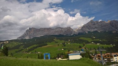 Val Gardena, İtalya - 09 / 15 / 2020: Arka planda büyülü Dolomitler dağları, Trentino Alto Adige bölgesinde inanılmaz bulutlar ve mavi gökyüzü, İtalya, Avrupa