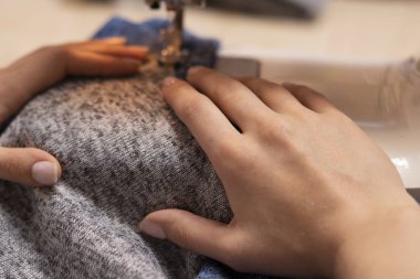 Terzi iş başında. Dikiş makinesinde yeni giysiler dikme.