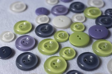 Multicolored buttons on white fabric.