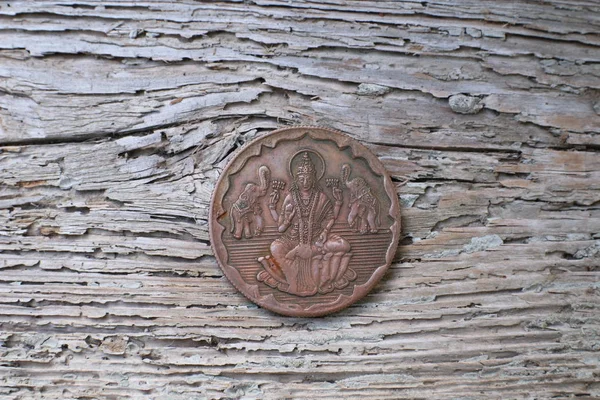 Ancient Indian copper coin on wood background