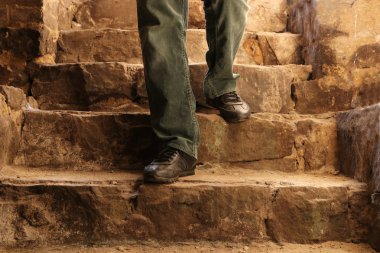Bir adam taş merdivenlerden bodruma iniyor. Antik Kale.