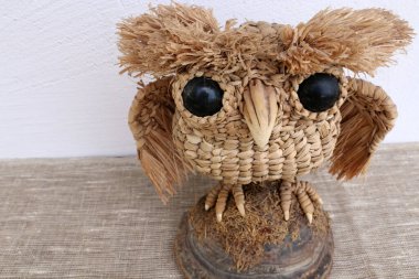 Handmade unique owl made of straw. Isolated on white background.