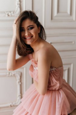 Pahalı parfüm reklamı tarzında bir fotoğraf. Büyük gözlü, güzel pembe elbiseli bir kızın portresi.