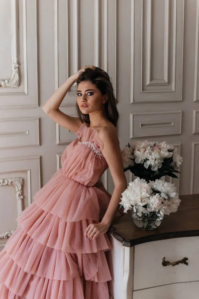 광고하는 스타일의 아름다운 드레스를 고전적 화실에 소녀가 꽃다발에둘러 — 스톡 사진