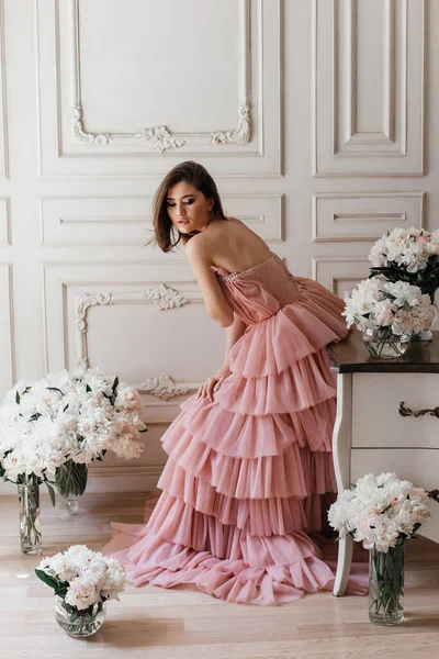 광고하는 스타일의 아름다운 드레스를 고전적 화실에 소녀가 꽃다발에둘러 — 스톡 사진