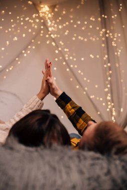 Birbirine aşık bir çiftin el ele tutuşması Noel ışıklarının arka planında