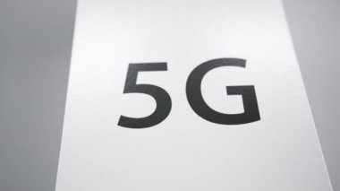 Beyaz arka planda beyaz parlak karton kutu, cihaz ya da akıllı telefon paketi, üstte 5G sembolü. Yeni teknoloji teslimatı kavramı. Kamera ters yakınlaştırma hareketi, 3g cgi 60 fps animasyon.