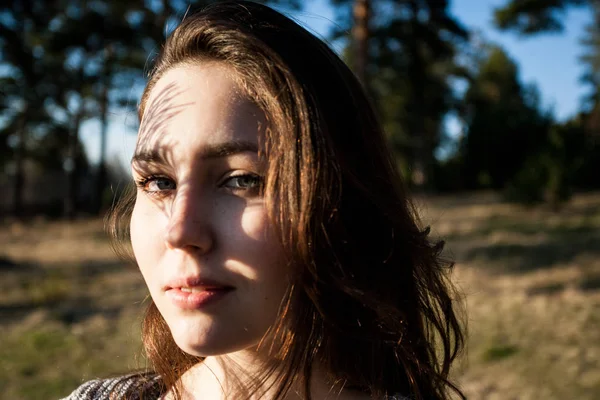 Çamın dalları yüzünden bir gölge büyüleyici bir kızla ensive portresi