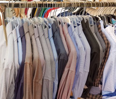Perakende mağazasının arka planında asılı duran gömlekler.