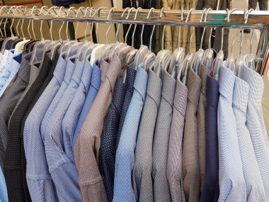 Perakende mağazasının arka planında asılı duran gömlekler.