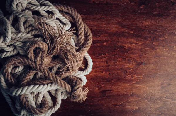 kahverengi ahşap yüzeyde bükülmüş halatlar 