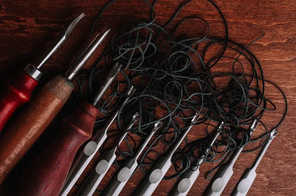 手工皮革工具和木制桌上的皮革绳 — 图库照片