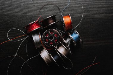 dikiş makinesi konu bobinleri ahşap masa yüzeyi, yatay imge