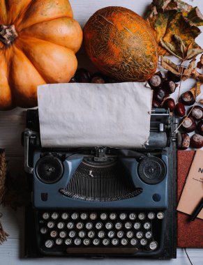 retro daktilo makinesi, kabak, at kestanesi ve yaprakları içeren tablo