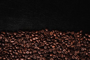 kahverengi kahve çekirdekleri, kahve arka plan ve siyah deri yüzey