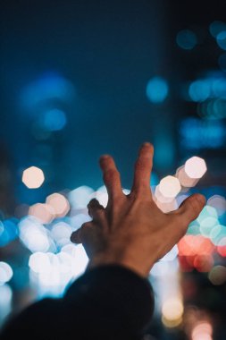 gece ışıkları bokeh ve erkek el 