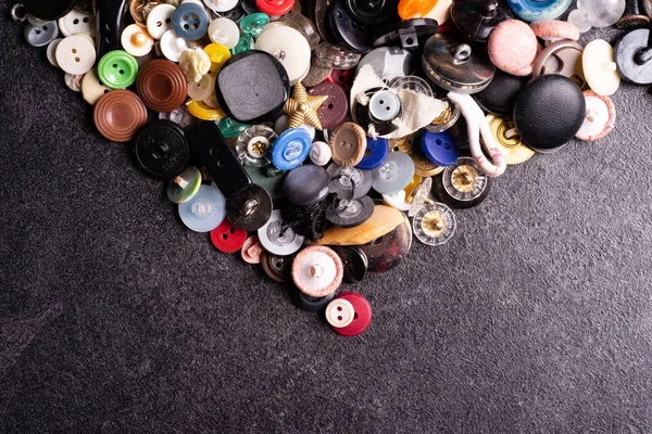 top view on messy colorful sewing buttons on leather table surface